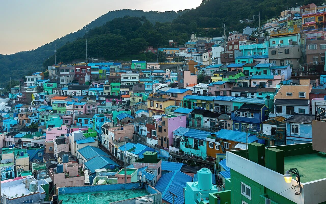 Colourful tiered houses of Gamcheon Culture Village on a Busan hillside at sunset.